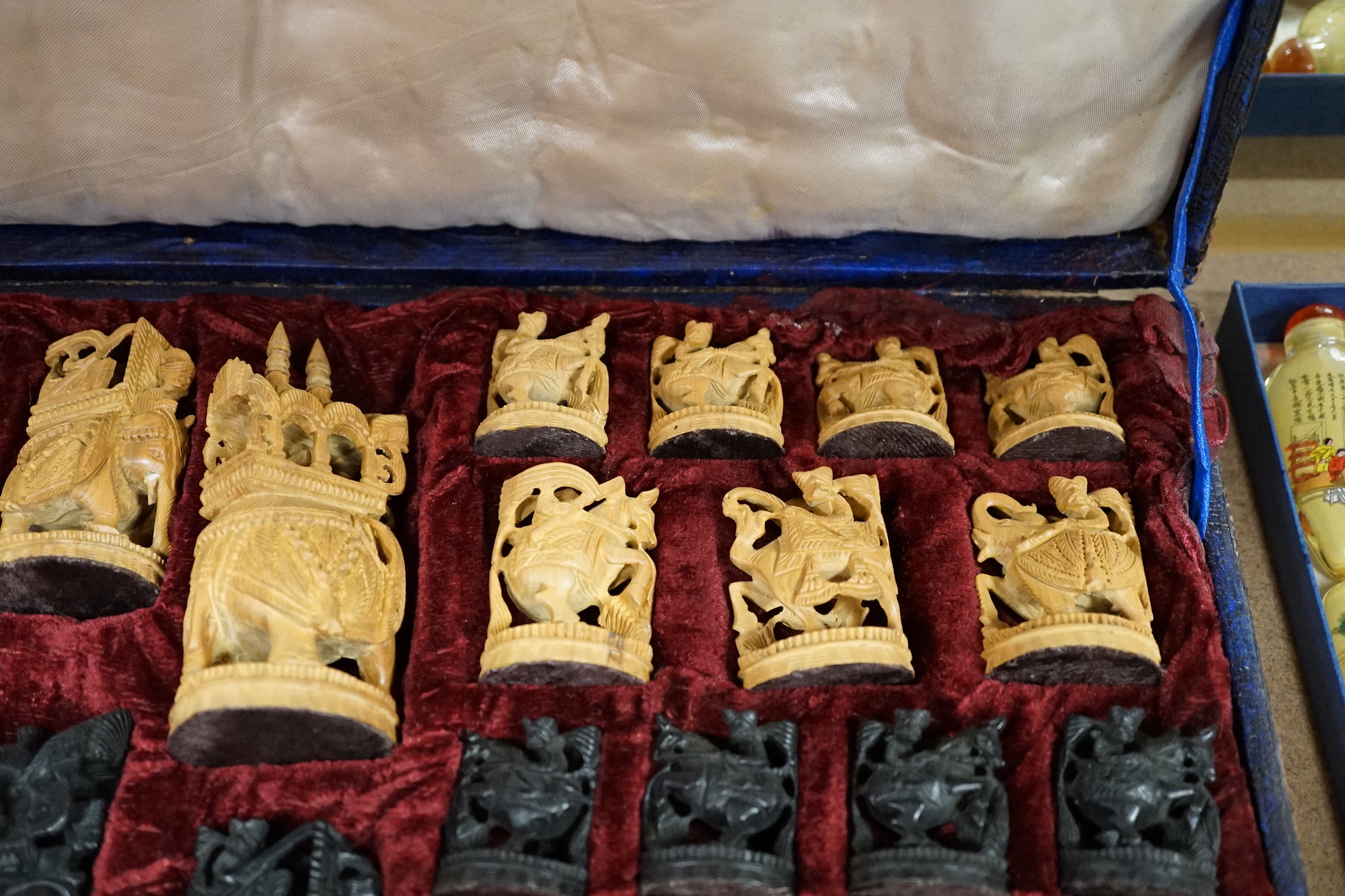A cased Indian sandalwood and ebony figural chess set, case 50.5cm wide